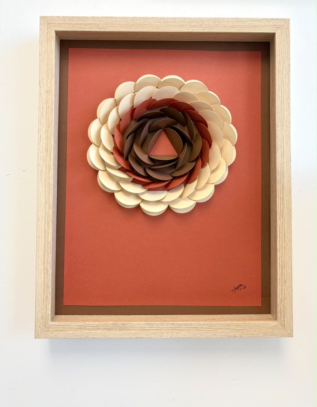 Framed paper bloom in burgundy and cream on a rust ground