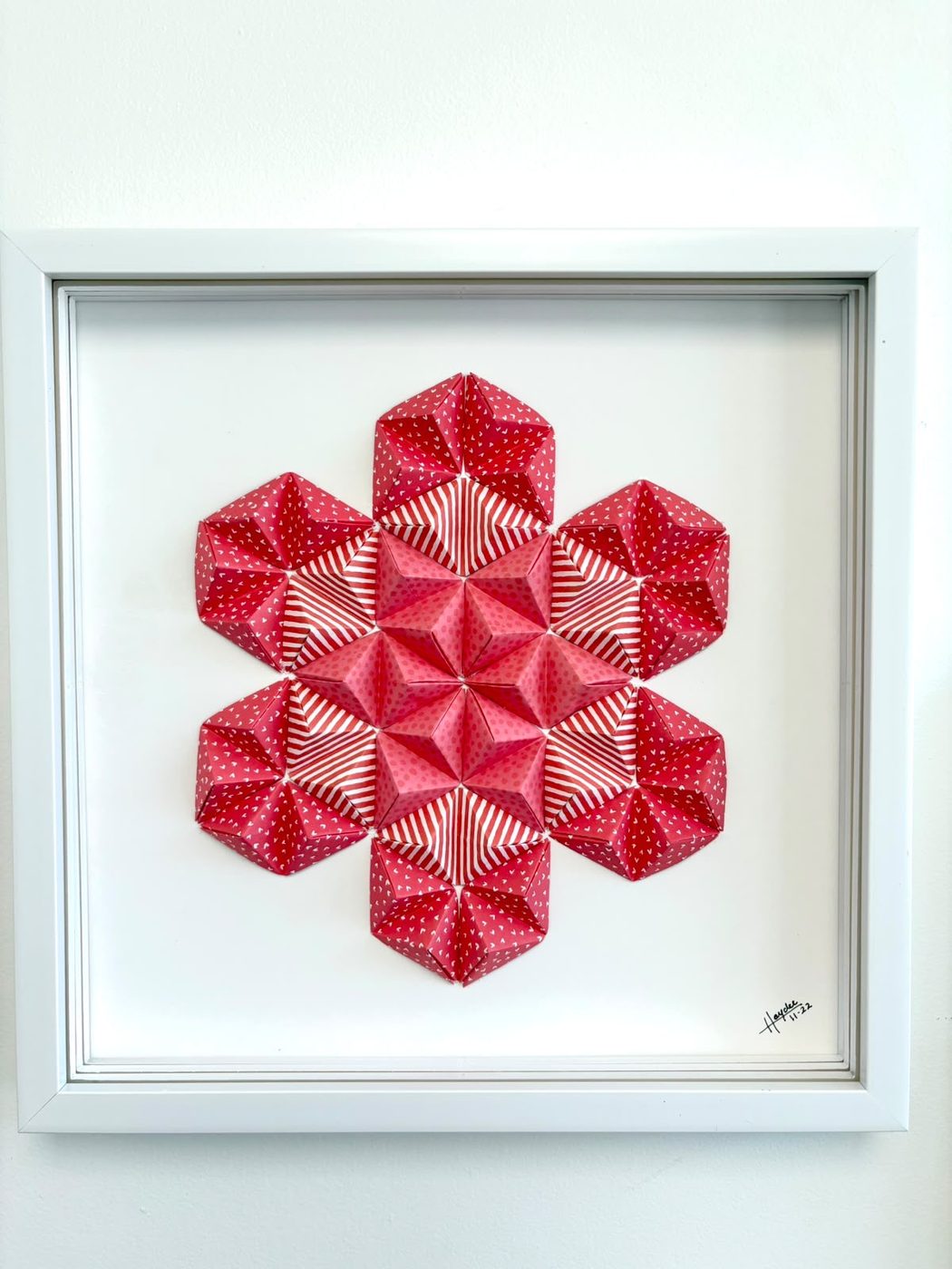 Framed origami star wall piece in red and pink