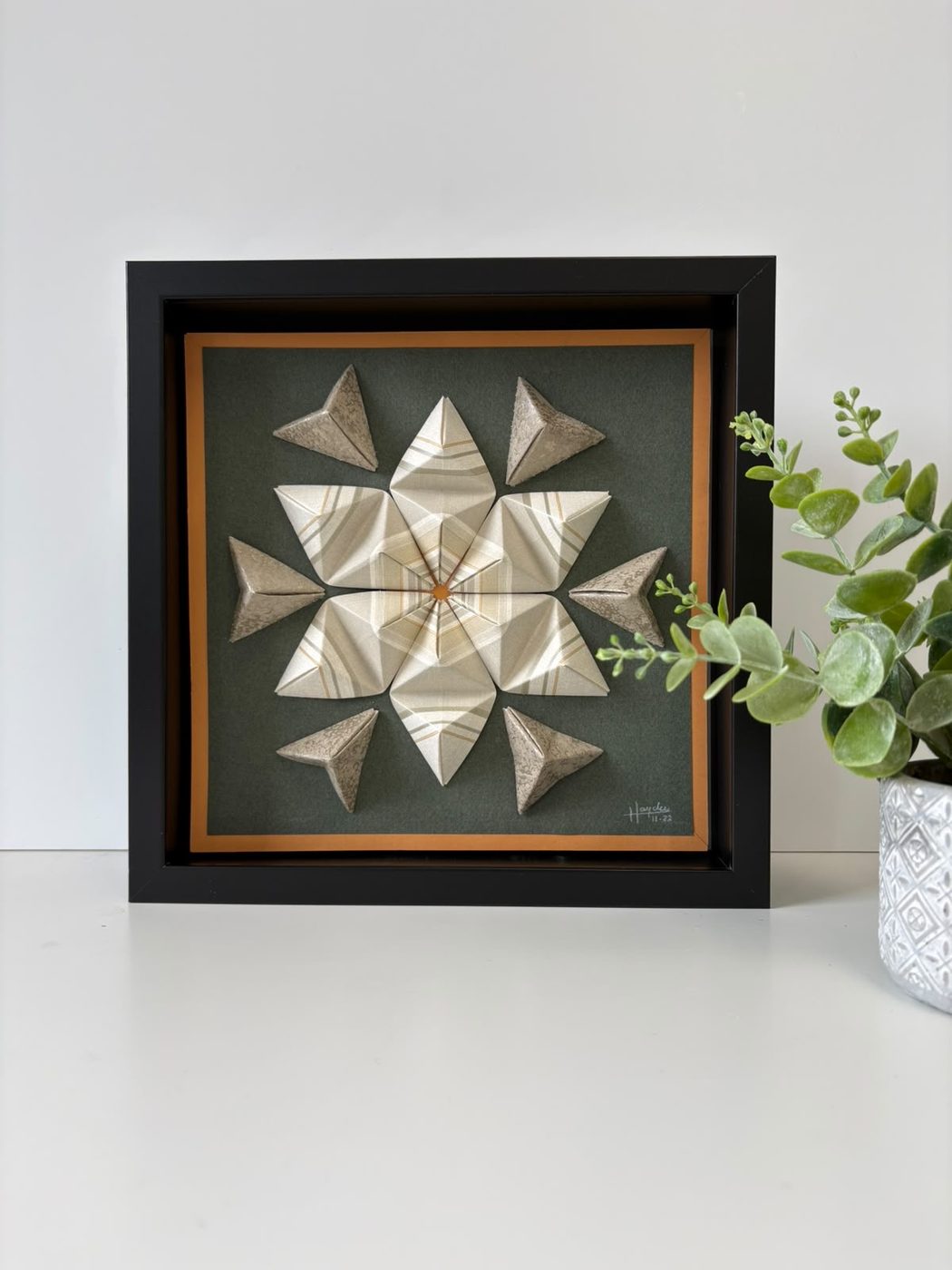 Framed origami star wall piece in tan, black and white