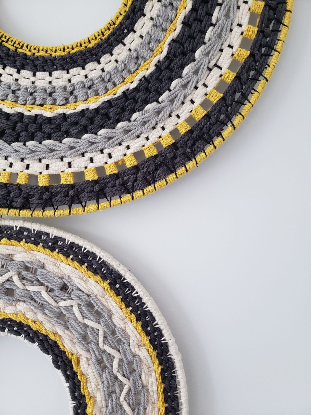 Detail of a woven circular wall piece in navy and yellow